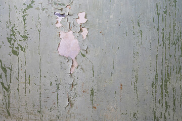 Peeling paint on the wall. Old concrete wall with cracked flaking paint. Weathered rough painted...
