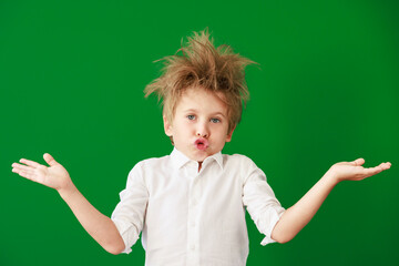 Surprised child against green chalkboard in class