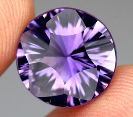 Natural gemstone purple amethyst on gray background