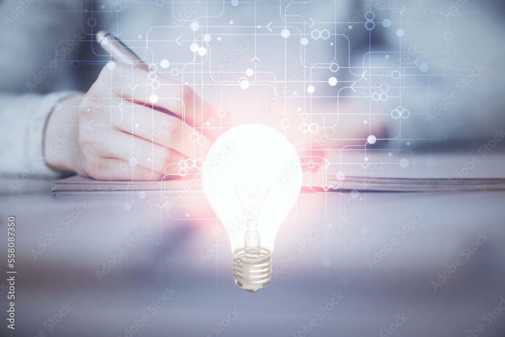 Poster bulb hologram over hands taking notes background. concept of idea. double exposure