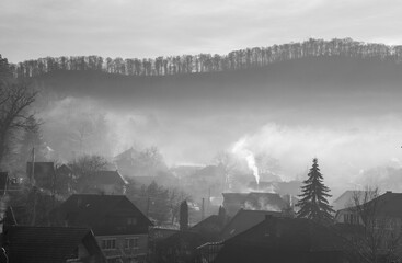 Smoke coming out of the chimneys of houses in a village in the morning