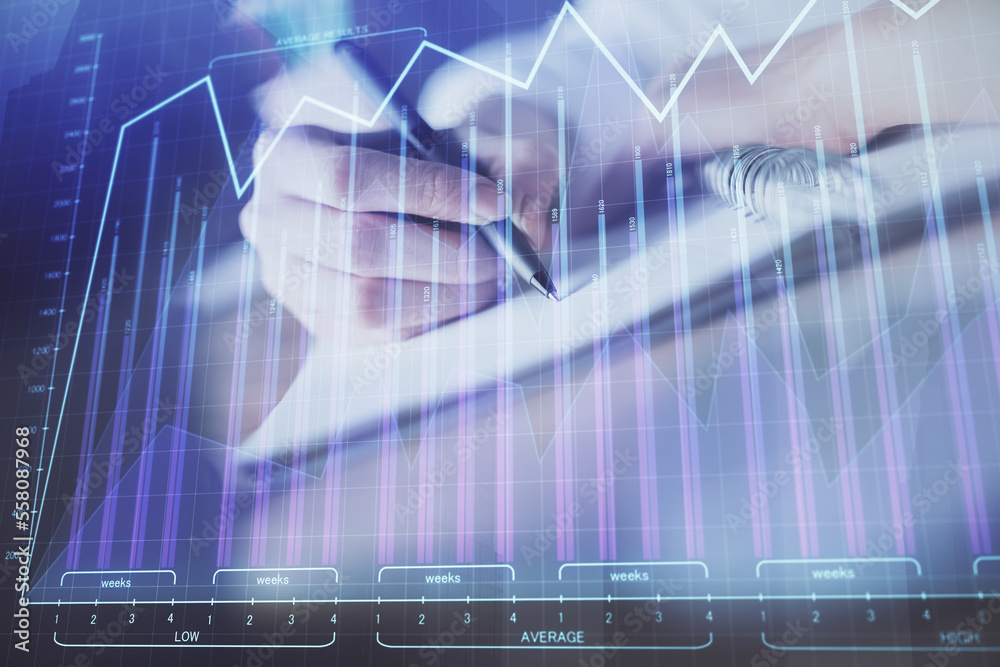 Wall mural financial forex graph displayed on hands taking notes background. concept of research. double exposu