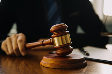 Business and lawyers discussing contract papers with brass scale on desk in office. Law, legal services, advice, justice and law concept picture with film grain effect