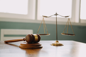 Business and lawyers discussing contract papers with brass scale on desk in office. Law, legal services, advice, justice and law concept picture with film grain effect