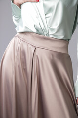 Studio shot of female fashion model in beige maxi circle skirt, Simplistic and elegant silk satin...