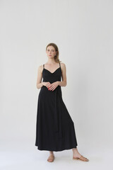 Fototapeta premium Serie of studio photos of young female model in comfortable yet stylish cotton black dress
