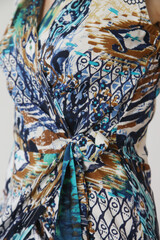 Serie of studio photos of young female model in colorful tropical print sleeveless wrap dress