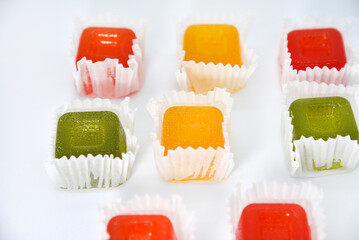Square slices of fruit marmalade on a white background. Delicious sweet marmalade. Multicolored slices of sweet marmalade.