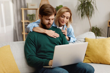 Couple Using Laptop Together. Husband And Wife Sharing Computer Social Network, Smiling And Searching For Funny Content. Technologies And People Concept 