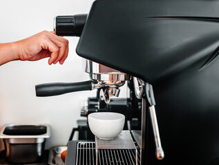 Close-up of hand barista making fresh coffee with the coffee machine in the cafe