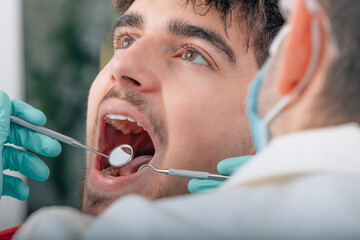 dentist working with tools in patient's mouth