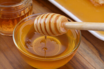 selective focus Honey dripping from honey dipper in a bowl. Close-up.