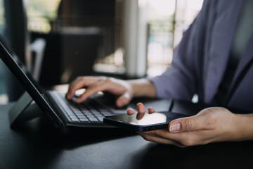 Asian colleagues man and woman discussing and working with laptop computer on office desk in the office