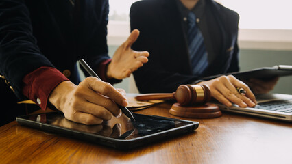 Business and lawyers discussing contract papers with brass scale on desk in office. Law, legal services, advice, justice and law concept picture with film grain effect