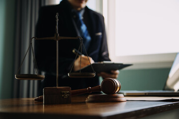 Business and lawyers discussing contract papers with brass scale on desk in office. Law, legal services, advice, justice and law concept picture with film grain effect
