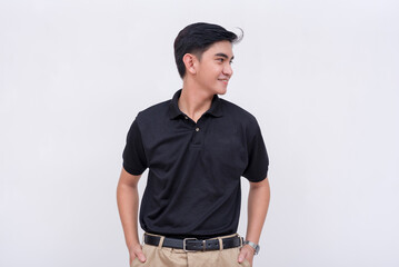 A handsome young filipino man with ear studs in a black polo shirt looking to his right. Isolated on a white background.
