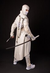 Combat ninja posing with two swords on a black background © AleksFil