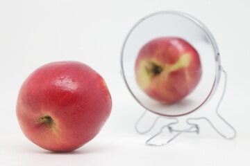 Bitten apple near the mirror with reflection, proper nutrition.