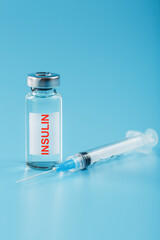 A bottle of insulin hormone and a syringe on the table