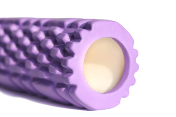 A purple foam massage roller isolated on a white background. Foam rolling is a self myofascial release technique. Gym fitness equipment.	