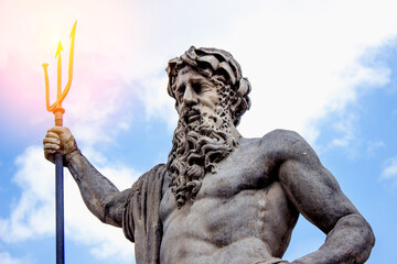 A statue of Neptune in a sunbeam on a blue sky background. Greek mythology © vlady1984