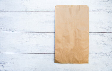 Brown paper bag on white wood background, eco friendly packaging, recycle paper bag