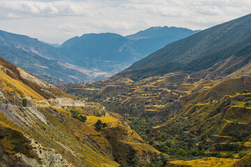 Snow-capped mountains and autumn fields. Beautiful mountain landscape in winter. Panoramic view, Dagestan, Russia.