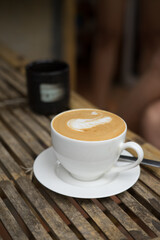 Cappuccino mit schöner Crema auf einem Holztisch.