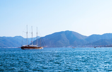 Fototapeta na wymiar Sailing ship in the sea near the picturesque mountain coast