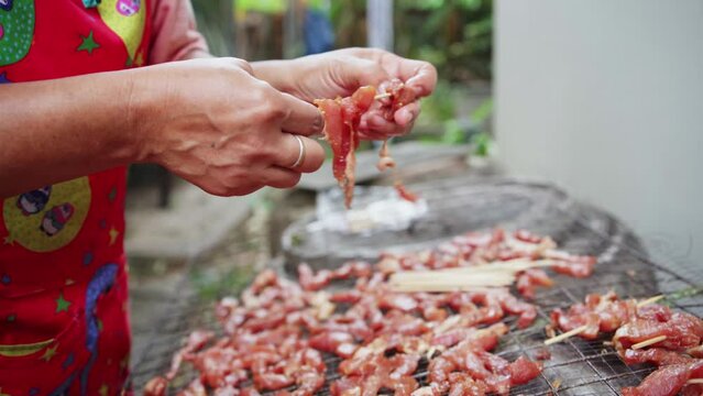Thai sun-dried pork (Moo Dad Deaw) skewer preparation for local street food