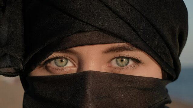 Young Woman in Hijab Open Her Green Eyes and Looking at Camera Portrait Close Up
