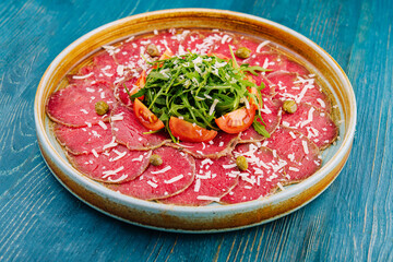 Beef carpaccio with capers, parmesan, arugula and tomatoes