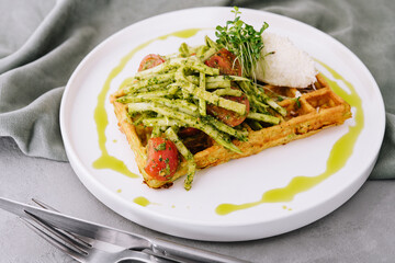 Closeup of tasty vegan potato waffle with pesto and fresh natural vegetables