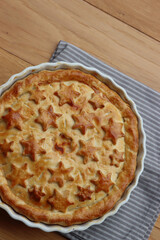 Italian Timballo or Timbale filled with pasta and bechamel with tomato sauce on wooden table