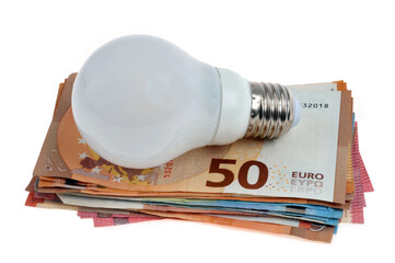 Concept de dépenses d'électricité avec une ampoule électrique sur une liasse de billets de banque en euros sur fond blanc - obrazy, fototapety, plakaty