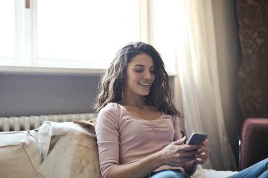 young woman uses a smartphone at home