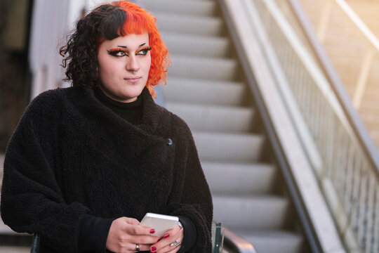 Transgender girl with painted hair posing to the camera.
