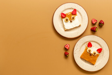 Kids breakfast with fox faces sandwiches made from peanut butter and strawberries