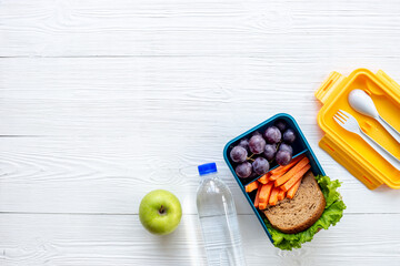 Lunch box set with bread fruits and vegetables, top view