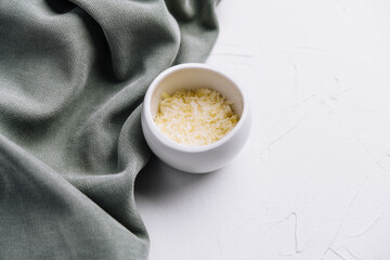 Grated aged italian parmesan cheese in white bowl