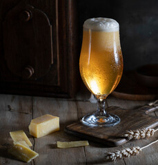 Glass of light beer on a wooden table
