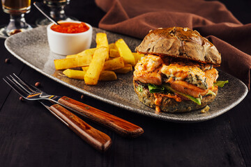 Burger with salmon, lettuce and fried potato