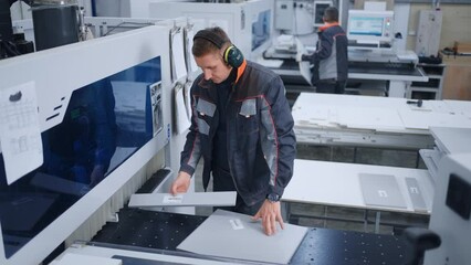 workers in woodworking workshop of modern furniture factory, operators work with CNC machines