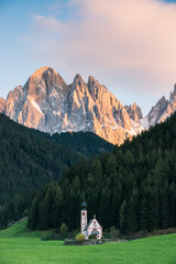 Fototapeta na wymiar Kleine Kapelle auf grüner Wiese in den Dolomiten in Südtirol mit einem Bergpanorama.