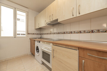 Fototapeta premium Kitchen Equipped with wooden cabinets of one color and the bases and countertop of another to match the stoneware floor