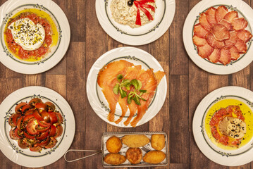 A wonderful table full of tapas food from Spanish bars, assorted croquettes, tuna belly, tomato salad, smoked salmon, loin steak and Russian salad