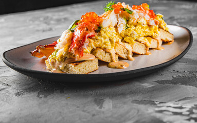 baked brioche, scrambled eggs, and crab meat on plate