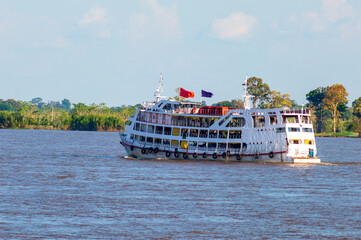 A cruise ship sailing on the Amazonas river in the middle of the amazon forest