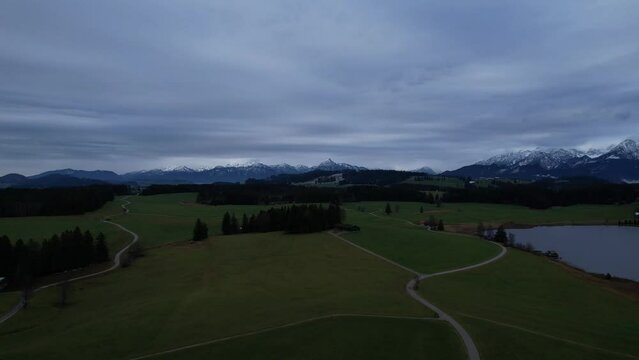 DRONE AERIAL FOOTAGE: Winter view from the Allgau Alps mountain range in the Northern Limestone Alps and alpine lake Attlesee, located near Nesselwang town, Bavaria, Germany.