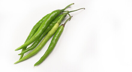 Fresh long Indian green chillies on wooden background.